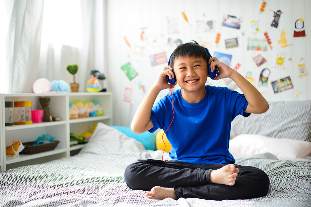 Child listening to music on bed