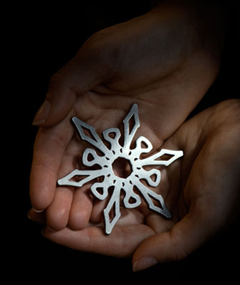 Hands holding a silver snowflake