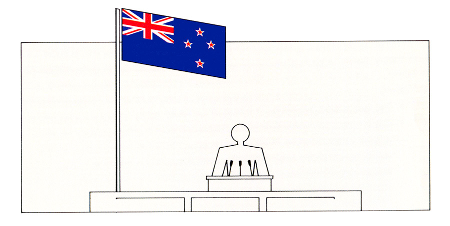 New Zealand flag flying to left of someone on speaking platform