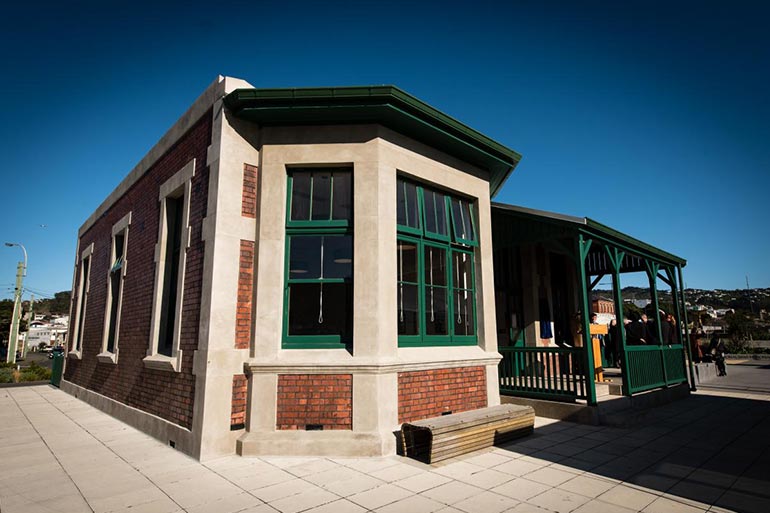 A brick building with green windows.