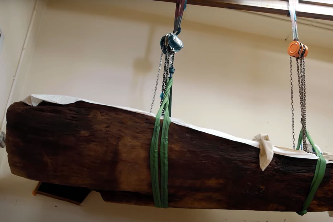 An old waka (canoe) being hoisted up in a room