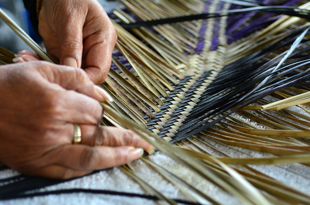 A woman weaving flax