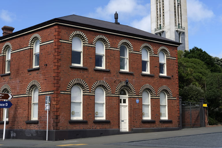 Old Mt Cook Police Station, a two story red brick building with a white door.