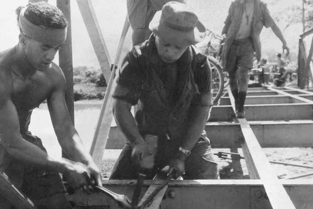 Two soldiers working on a steel bridge