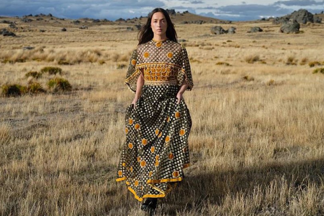 Model wearing a 1970s dress with the Otago landscape behind her