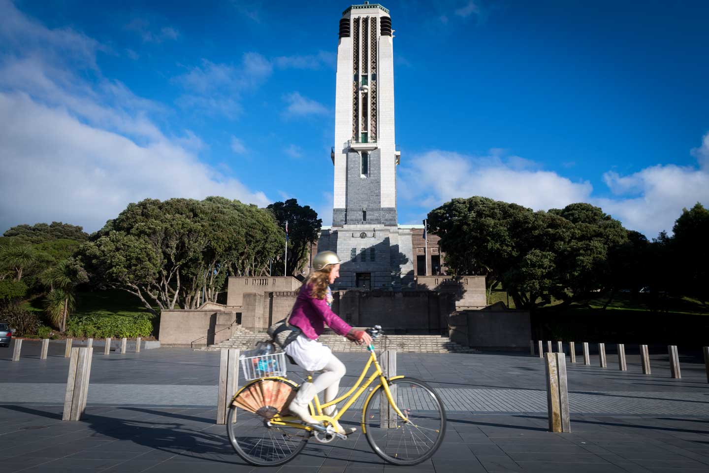 Woman on yellow bike riding in front of the National War Memorial