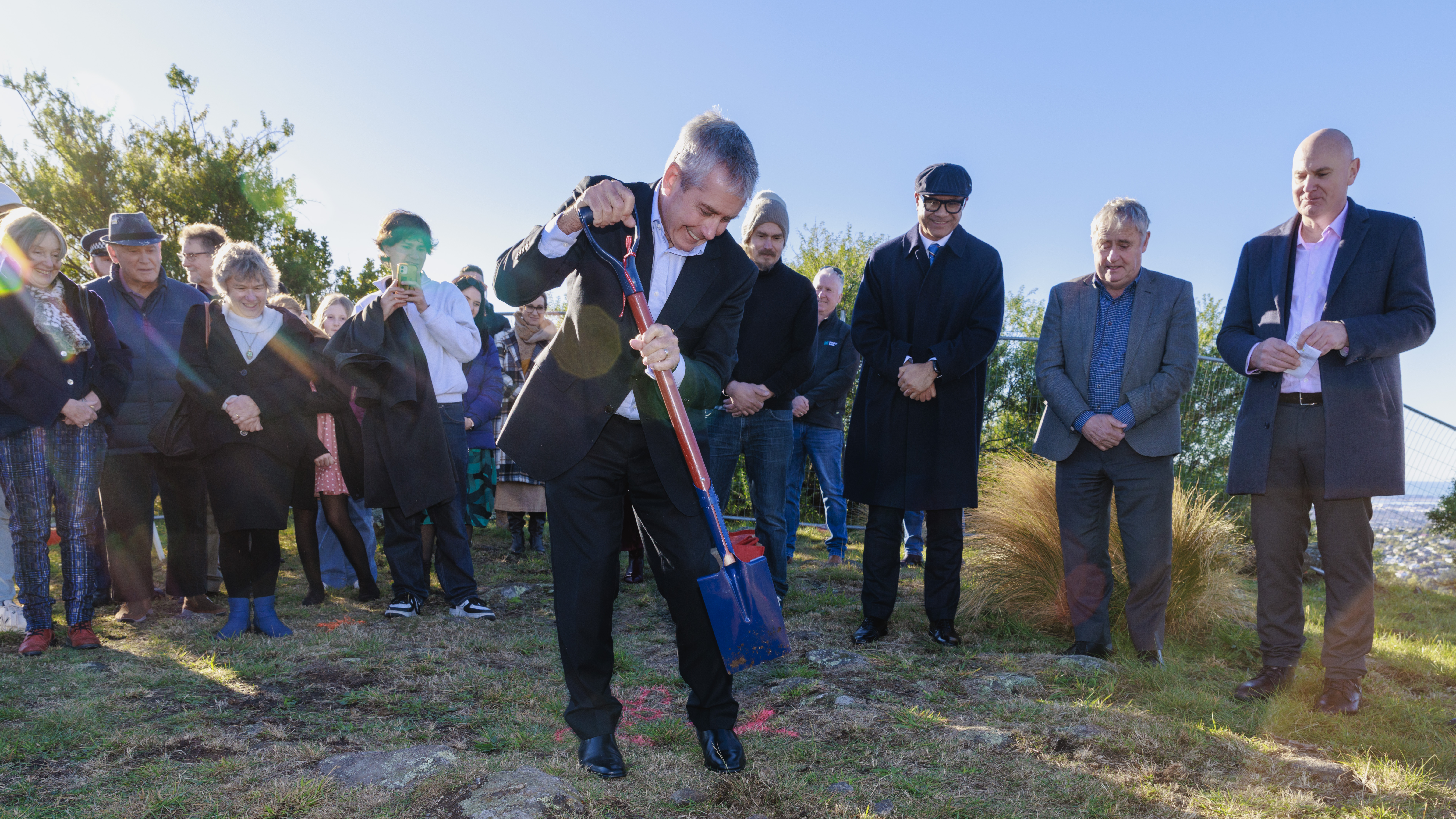 Man with spade surrounded by small crowd