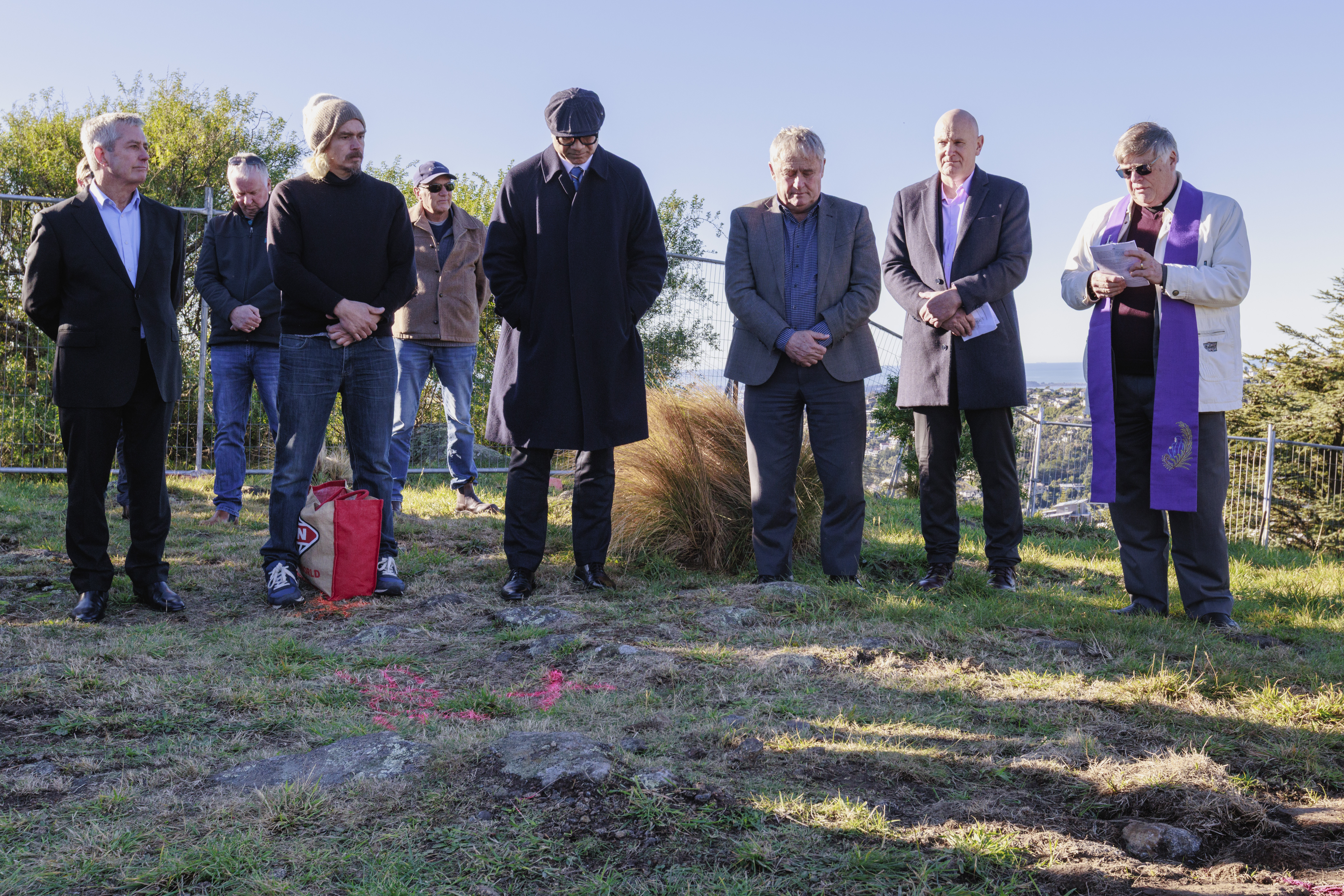 Group, two with spades, standing around site of first sod ceremony