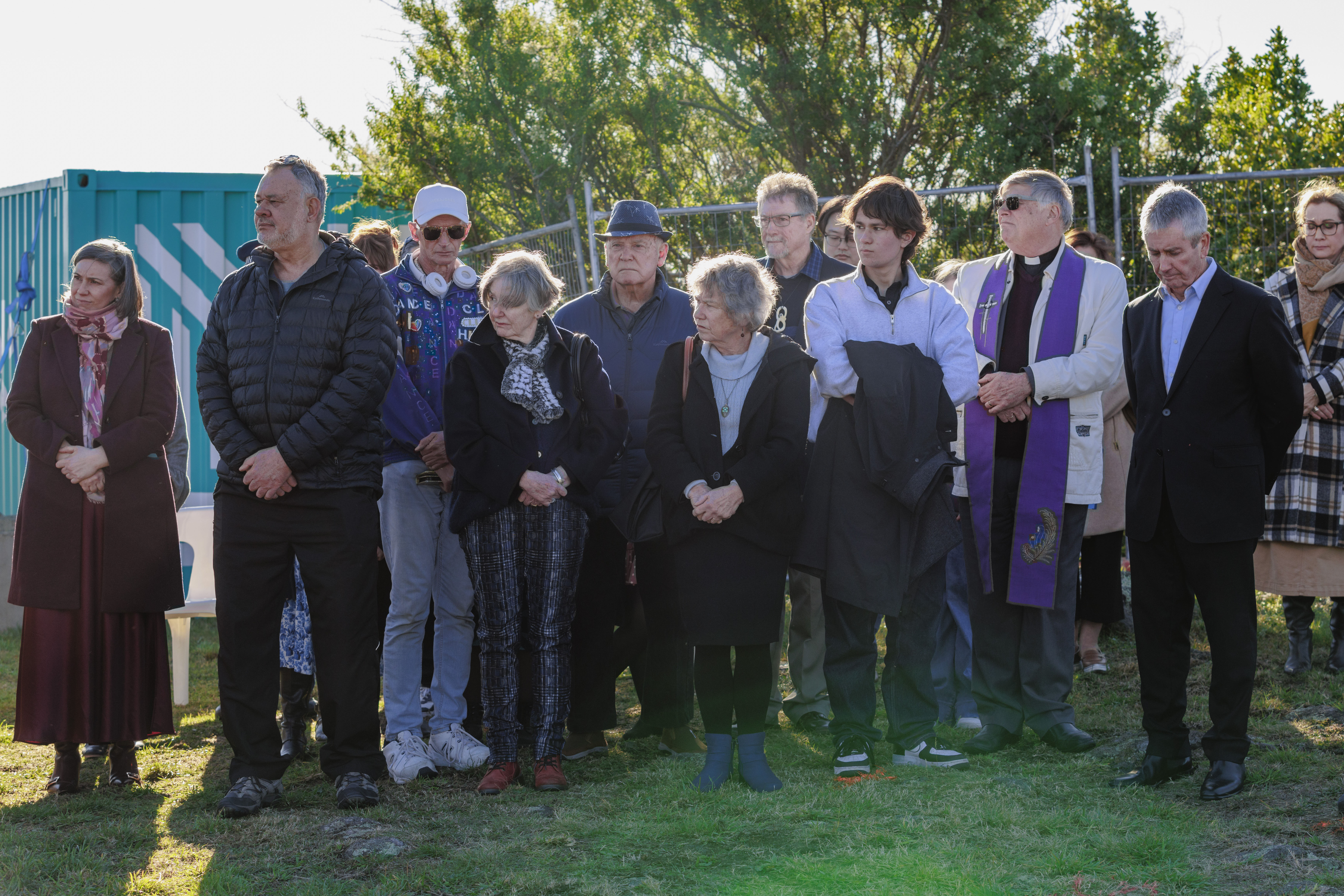 Group standing around in prayer at ceremony