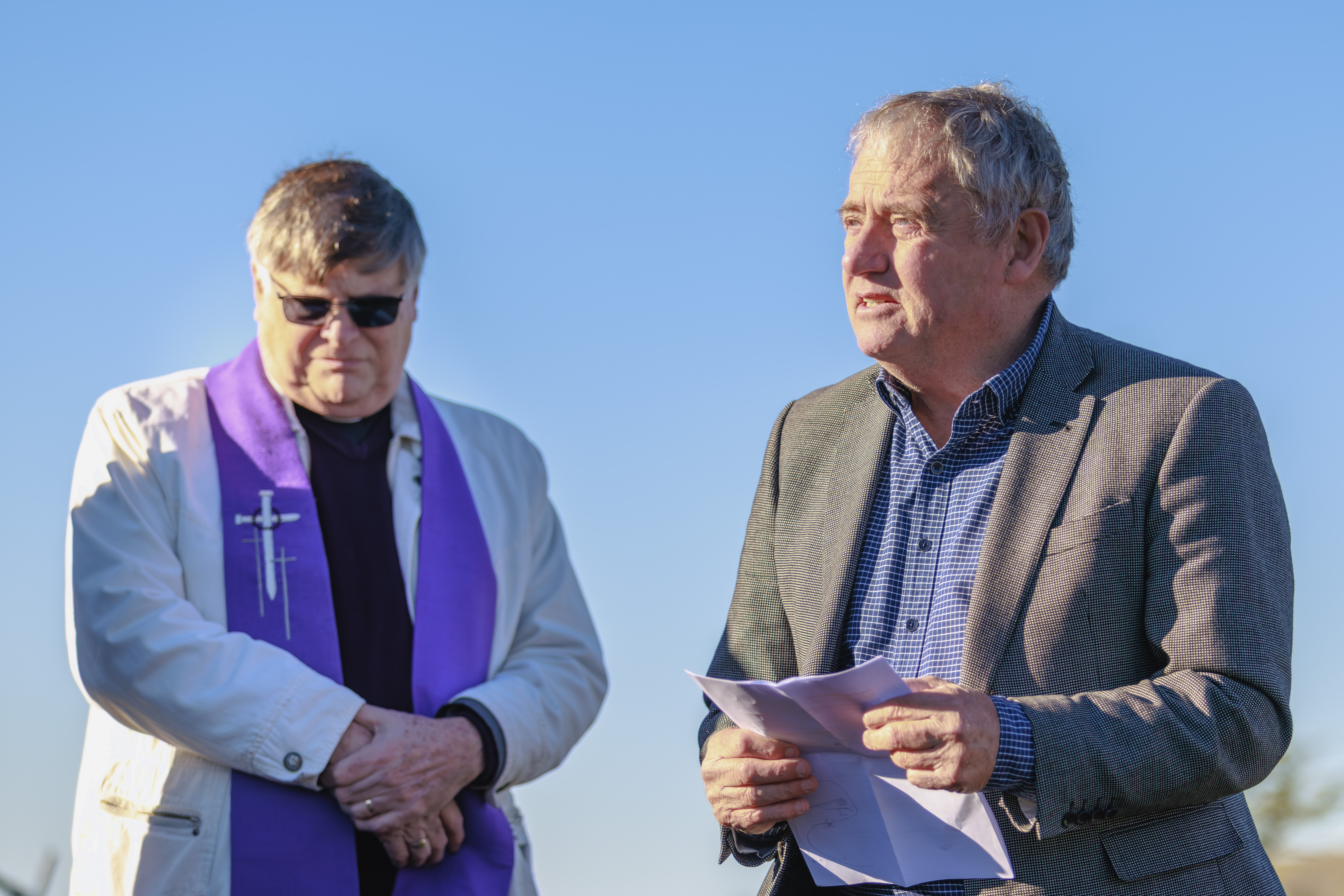 Two men at blessing, one in church clothing
