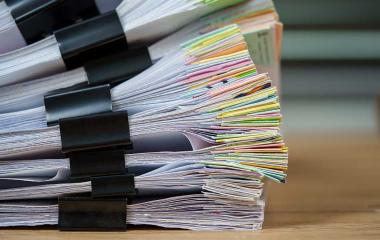 A stack of papers held together with bulldog clips
