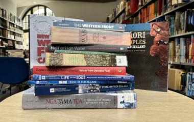 a stack of books on a table in a library. 