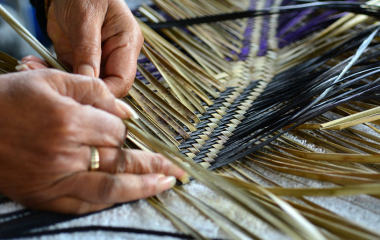 A woman weaving flax