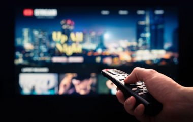 A hand pointing a remote at a tv screen.