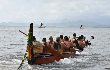 Waka full of paddlers heading out to sea