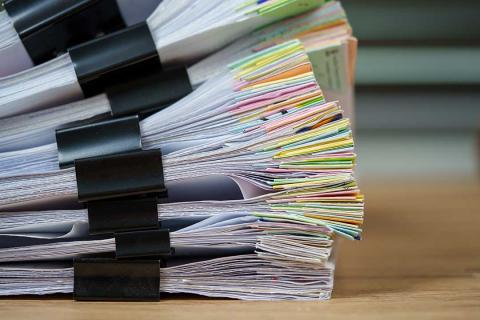 A stack of papers held together with bulldog clips