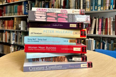 a stack of books on a table in a library. 